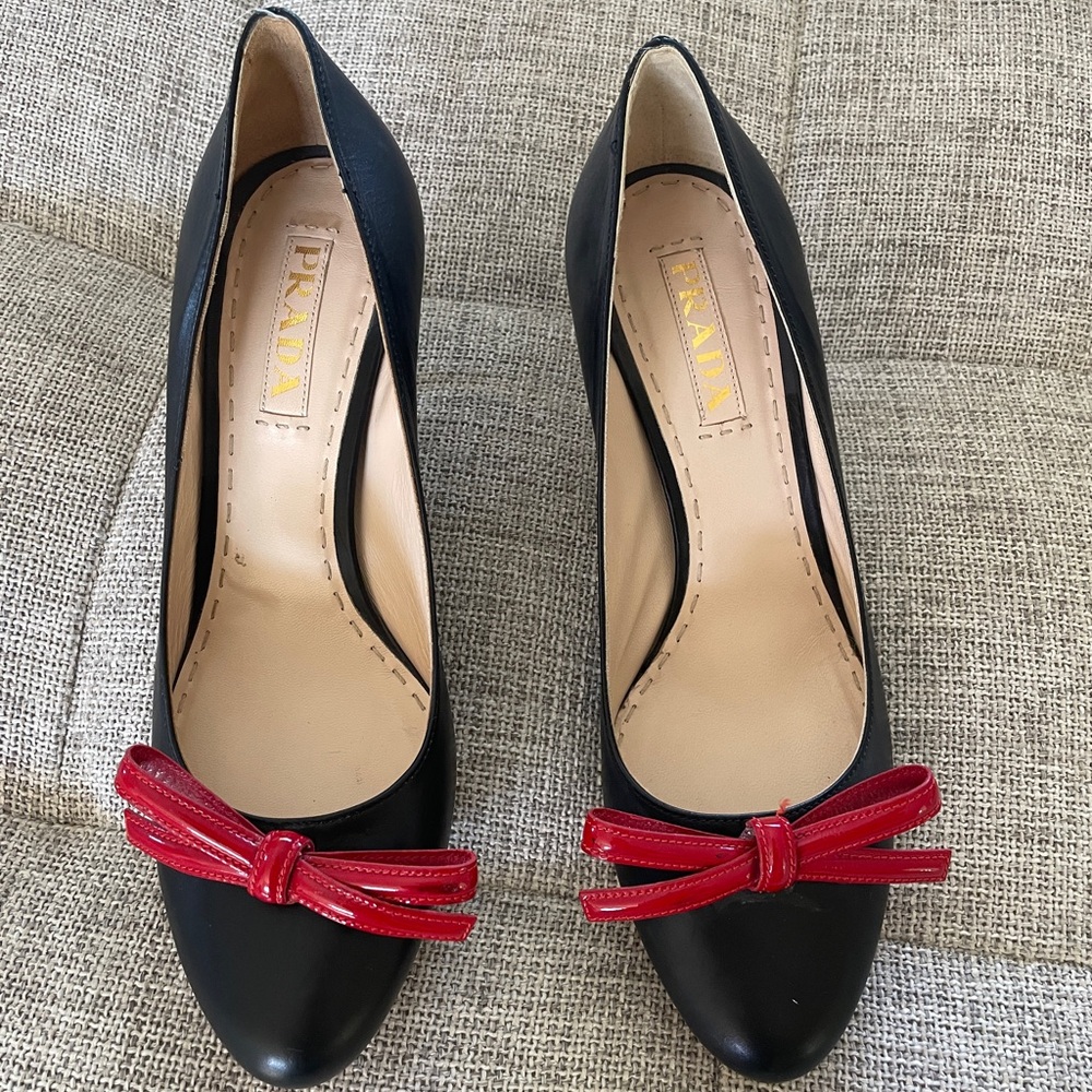 Black leather Prada pumps with red bows